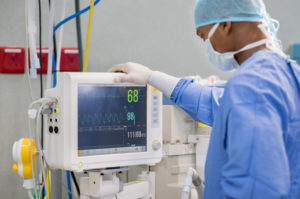 Cardiac Anesthesiologist monitoring patient during heart surgery