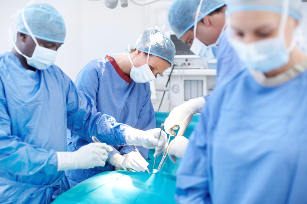 Group of surgeons working on a patient lying down on an operating table during an operation
